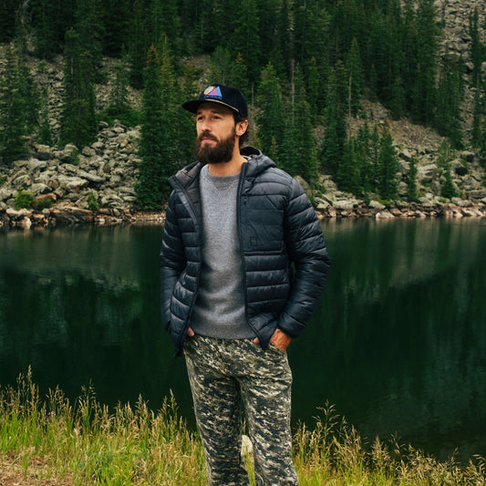 General image of man standing by a lake with mountains in the background