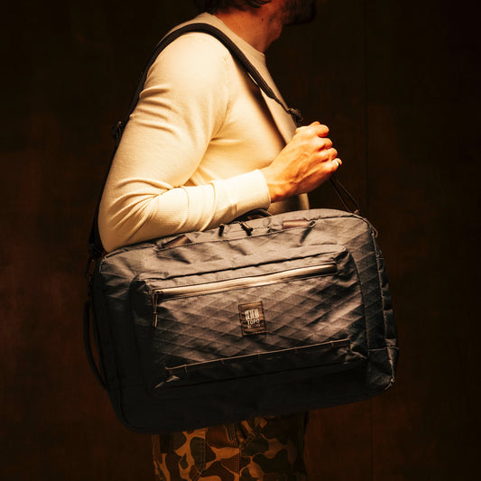 General shot of Topo Designs Global Pro 3-Way Briefcase in studio setting showing over the shoulder strap
