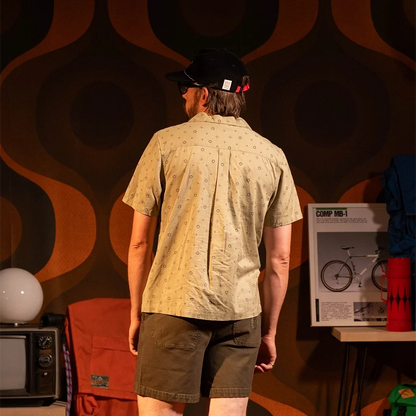 General back view of Topo Designs Daytripper Short Sleeve - Men's in "Tossed Motif Oil Green"