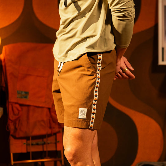 General model lifestyle photo of Topo Designs Mountain Wave Shorts on male model in "Desert Palm"