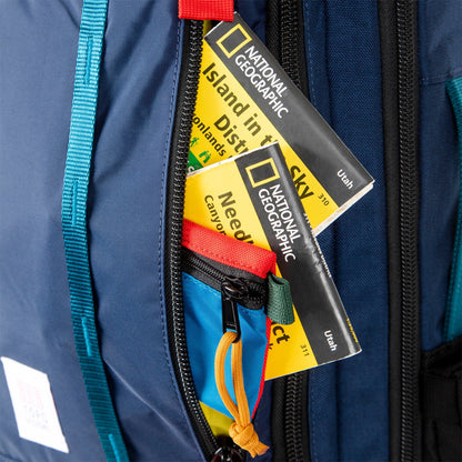 Shot of Topo Designs Global Travel Bag 30L Durable Carry On Convertible Laptop Travel Backpack in Navy blue with maps showing front zipper pocket.