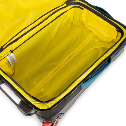 Shot of yellow interior compartment of Topo Designs Global Travel Bag Roller durable carry-on convertible laptop rolling backpack suitcase in Navy blue.