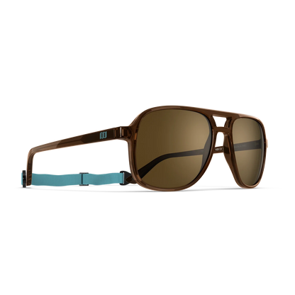 General alternate angled view of VALLON X Topo Designs sunglasses in "Brown / Brown" with sunglass arms open with strap attached.