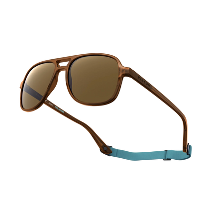 General alternate angled view of VALLON X Topo Designs sunglasses in "Brown / Brown" with sunglass arms open with strap attached.