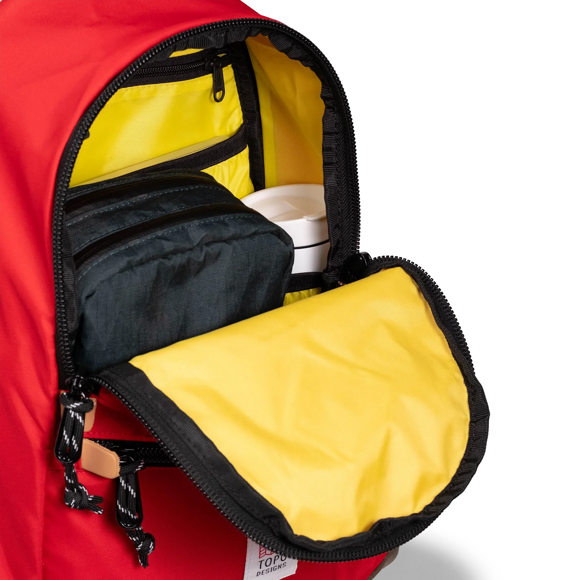 General detail view of Topo Designs Classic Teardrop Backpack in "Salsa" with the main compartment opened.