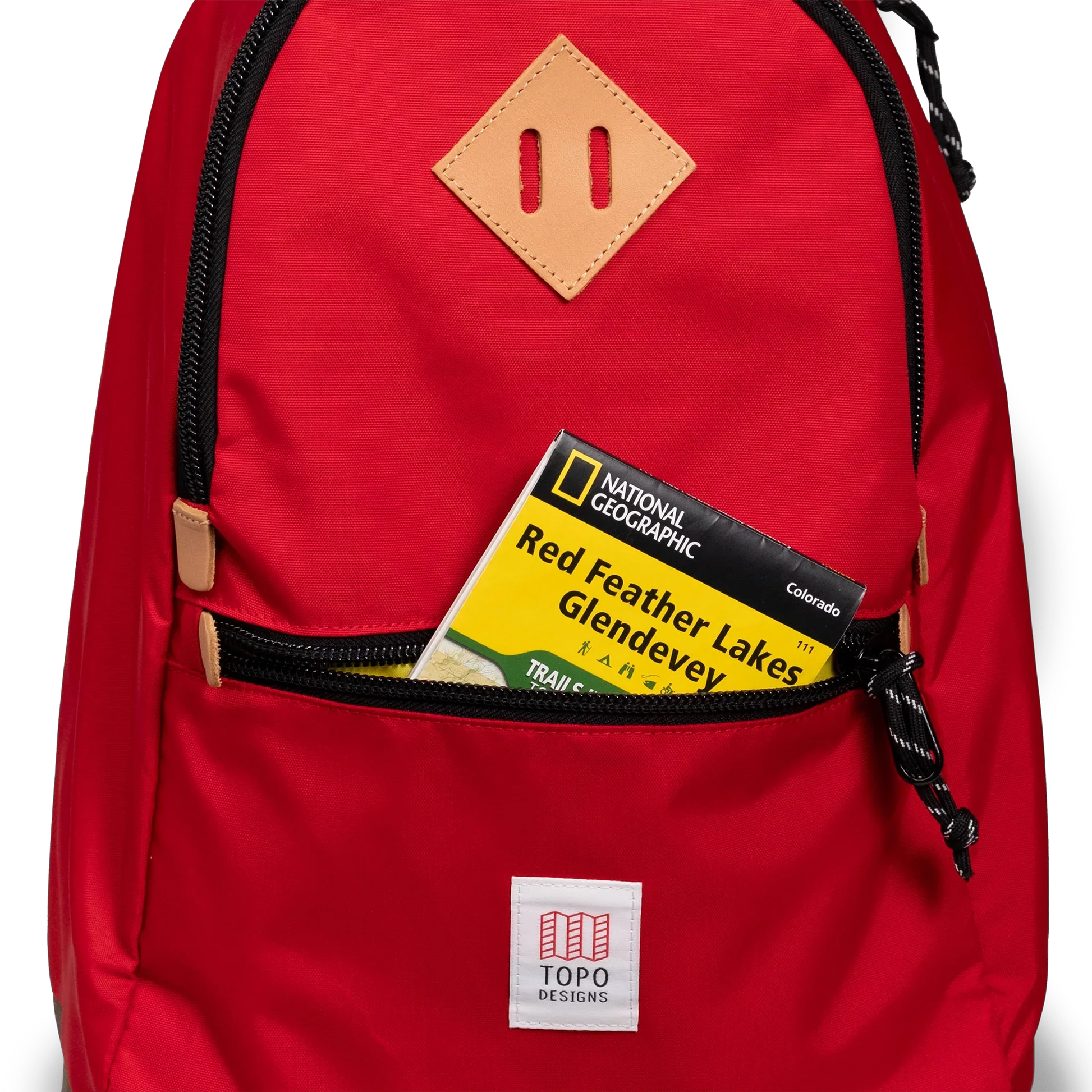 General detail view of Topo Designs Classic Teardrop Backpack in "Salsa" with the front zippered pocket opened.