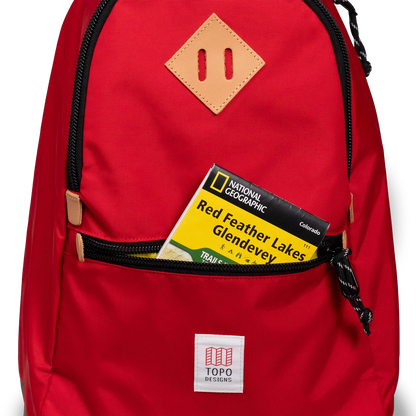 General detail view of Topo Designs Classic Teardrop Backpack in "Salsa" with the front zippered pocket opened.