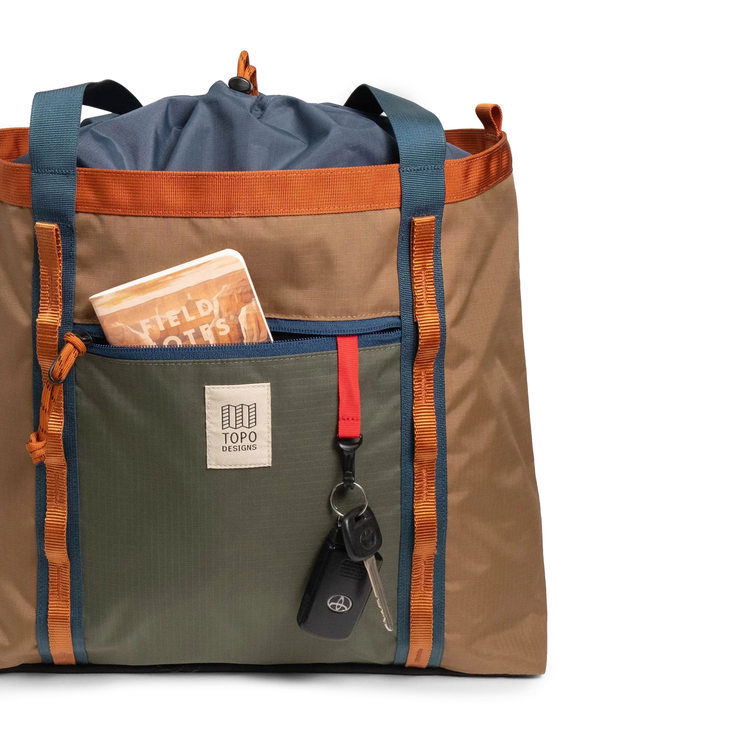 General front view of Topo Designs Mountain Utility Tote in "Olive / Dark Khaki" with notebook and keys.