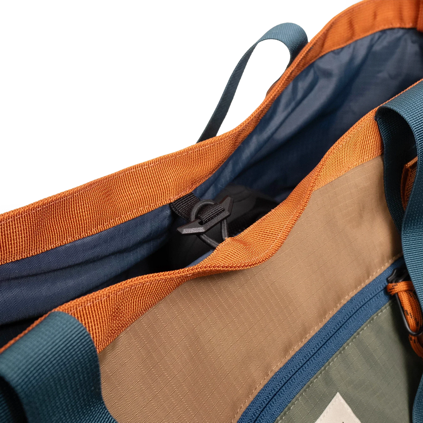 General detail shot of Topo Designs Mountain Utility Tote compartment toggle in "Olive / Dark Khaki".