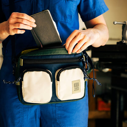 General lifestyle photo of model with Topo Designs Block Bag in "Forest / Bone White"